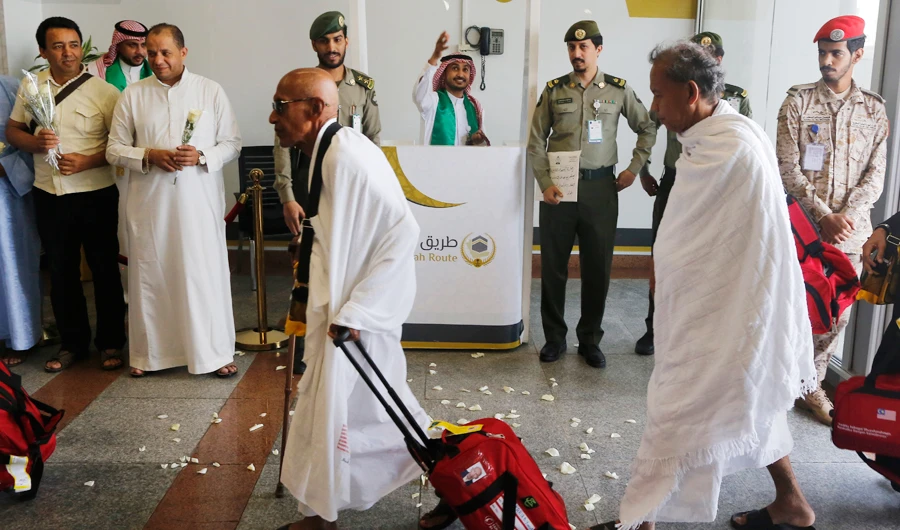 A Saudi airport worker throws flowers as he welcomes Malaysian pilgrims at the Hajj Terminal at Jiddah airport, Saudi Arabia, Saturday, Aug. 3, 2019. (AP)