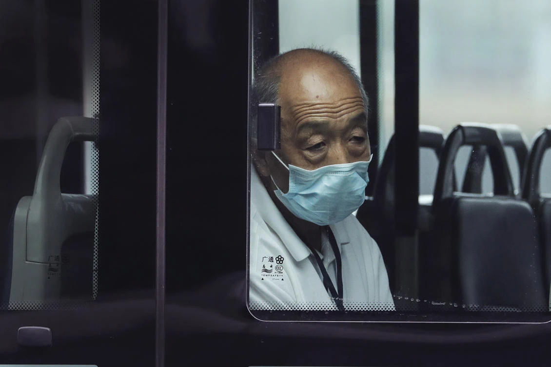 A man wearing a face mask to protect against the new coronavirus rides alone on a bus in Beijing, Tuesday, July 28, 2020. New coronavirus cases continue to rise in China's northwestern region of Xinjiang, with more than dozens reported on Tuesday. (AP)