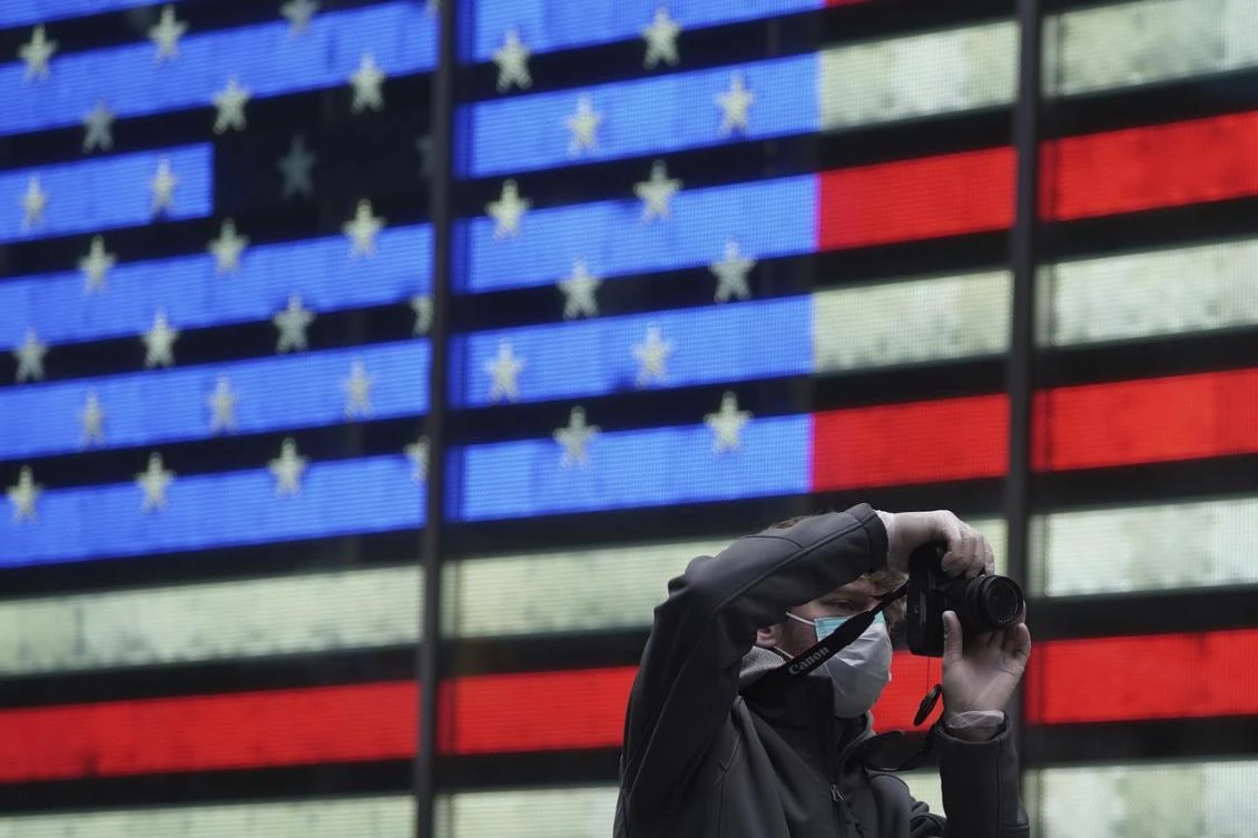A man wearing a mask takes photos in Times Square following the outbreak of COVID-19, in the Manhattan borough of New York City, New York, US, March 17, 2020. (Reuters)