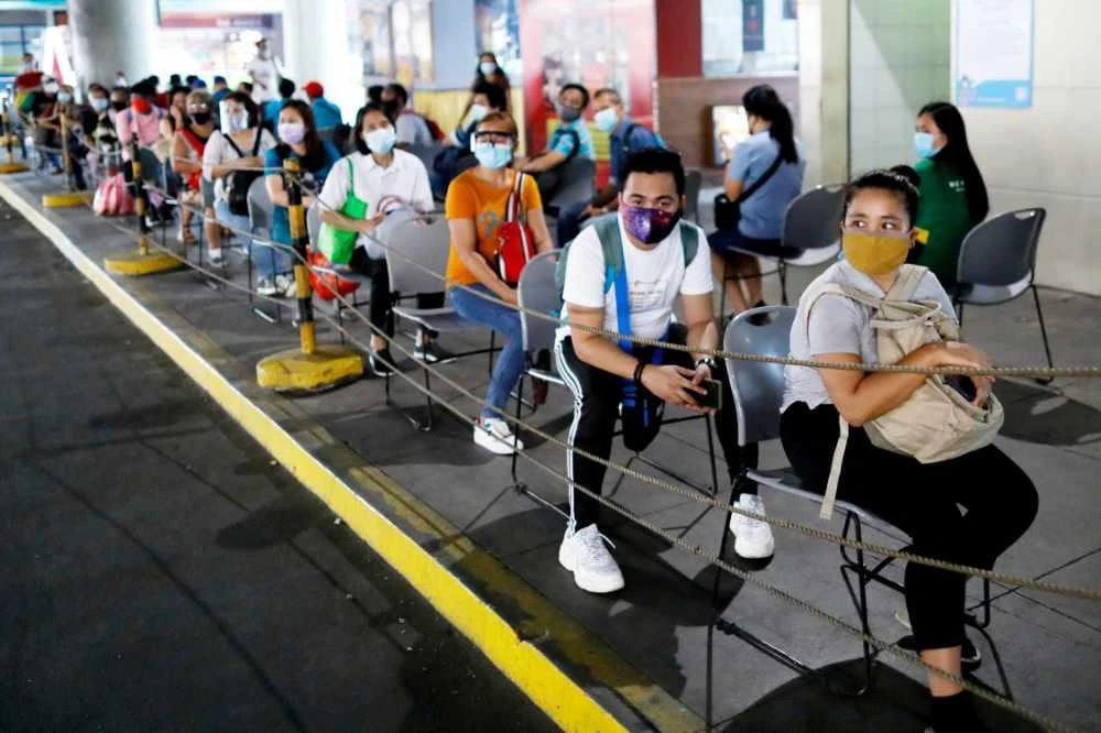 Passengers wearing masks for protection against COVID-19 maintain social distancing while queueing to ride a bus in Quezon City, Metro Manila, Philippines. (REUTERS/Eloisa Lopez/File Photo)