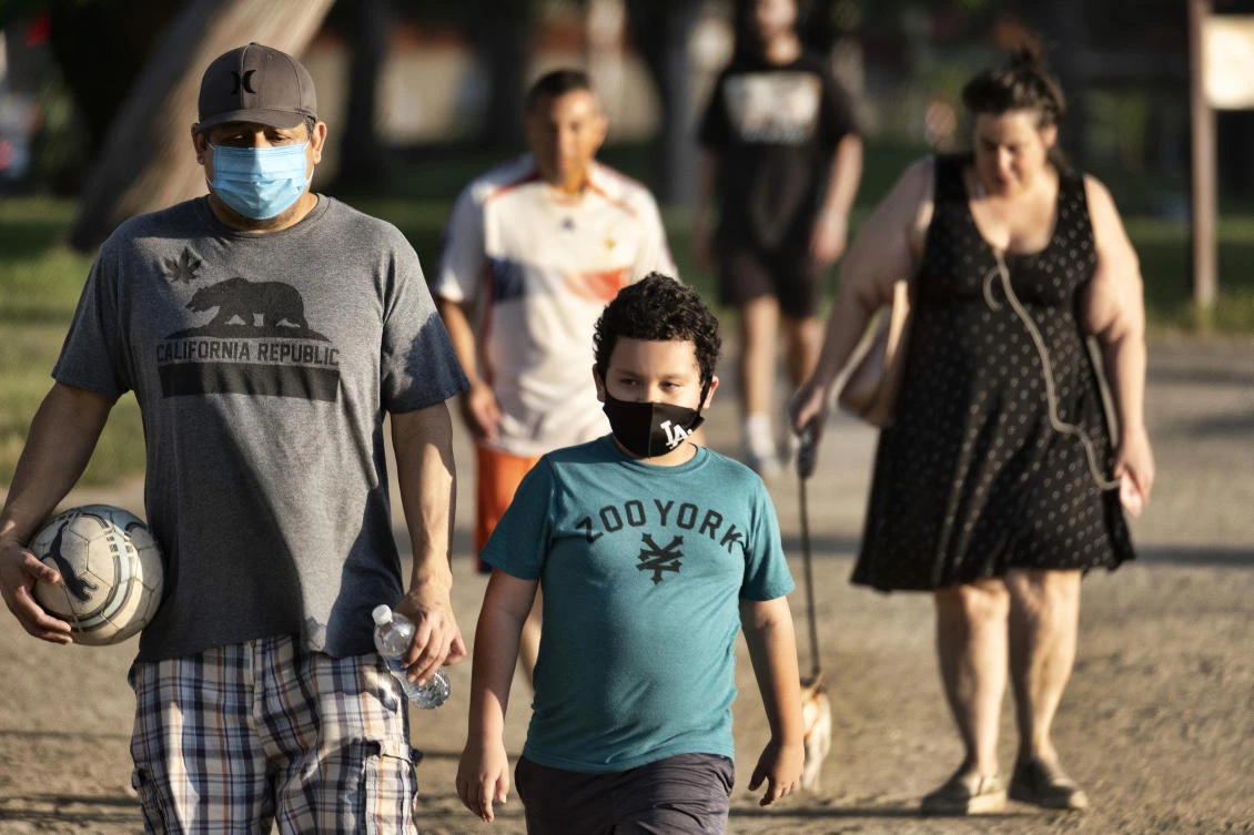 In this May 9, 2020, file photo, adults and children wearing masks amid the coronavirus pandemic exercise around a track at the Van Nuys/Sherman Oaks Recreation Center, in the Sherman Oaks section of Los Angeles. (AP)