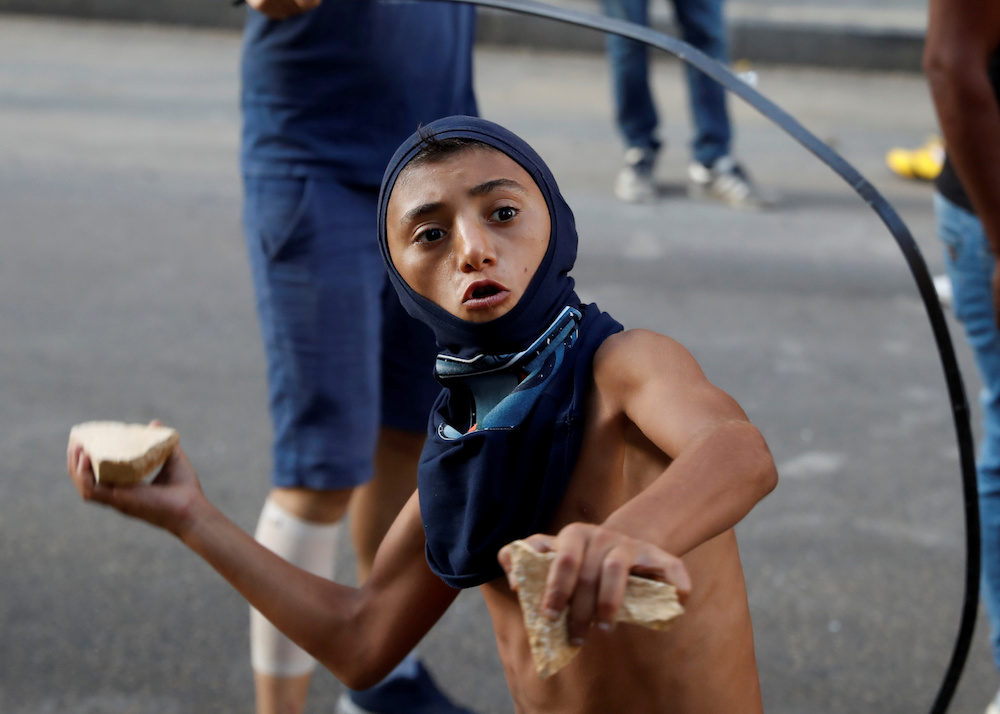 A demonstrator throws a stone during a protest in Beirut, Lebanon, August 10. (Reuters)