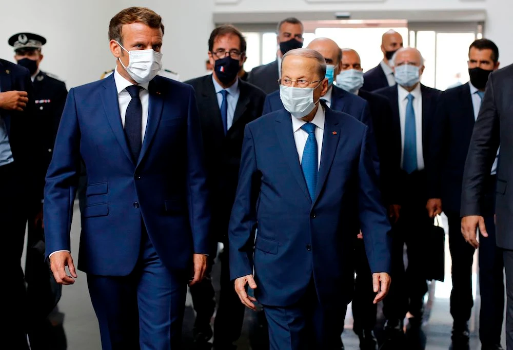 French President Emmanuel Macron (L) walks with Lebanese President Michel Aoun upon his arrival at Beirut airport, on August 6, 2020 two days after a massive explosion devastated the Lebanese capital in a disaster that has sparked grief and fury. (AFP)