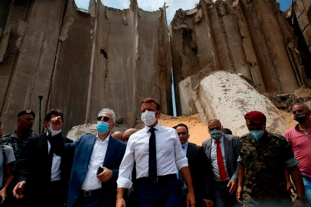 French President Emmanuel Macron (C), surrounded by Lebanese servicemen, visits the devastated site of the explosion at the port of Beirut, on August 6, 2020 two days after a massive explosion devastated the Lebanese capital. (AFP)