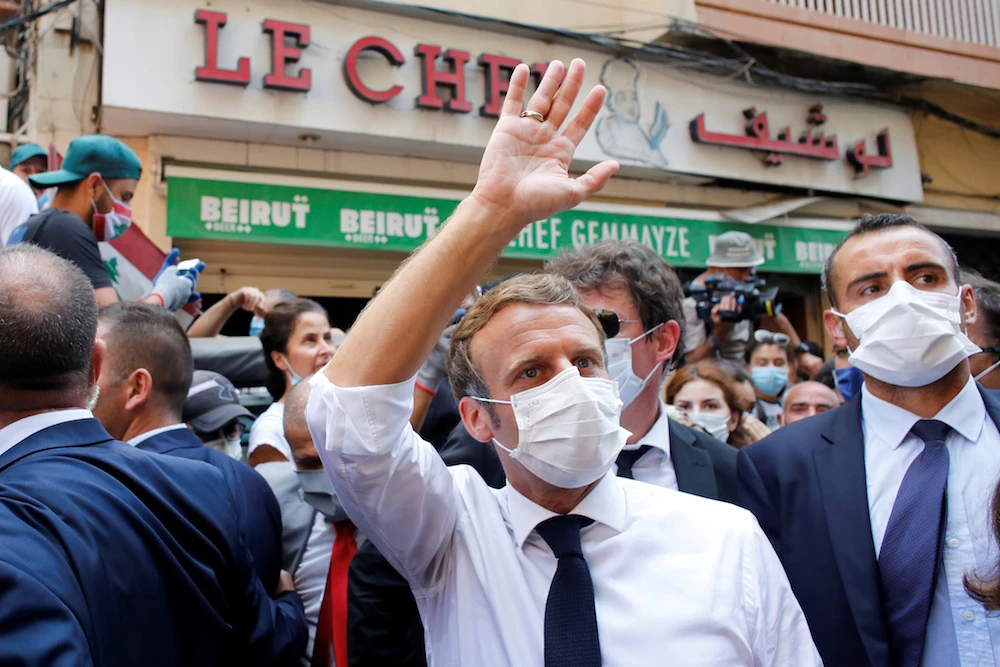 French President Emmanuel Macron waves as he visits a devastated street of Beirut. (Reuters)