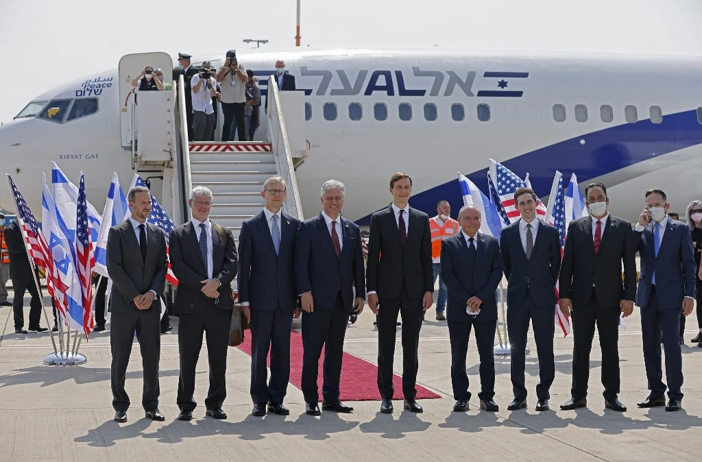 US Presidential Adviser Jared Kushner, center right,  and US National Security Adviser Robert O’Brien, center lef, pose with members of the Israeli-American delegation in front of the El Al’s flight LY971. (AFP)