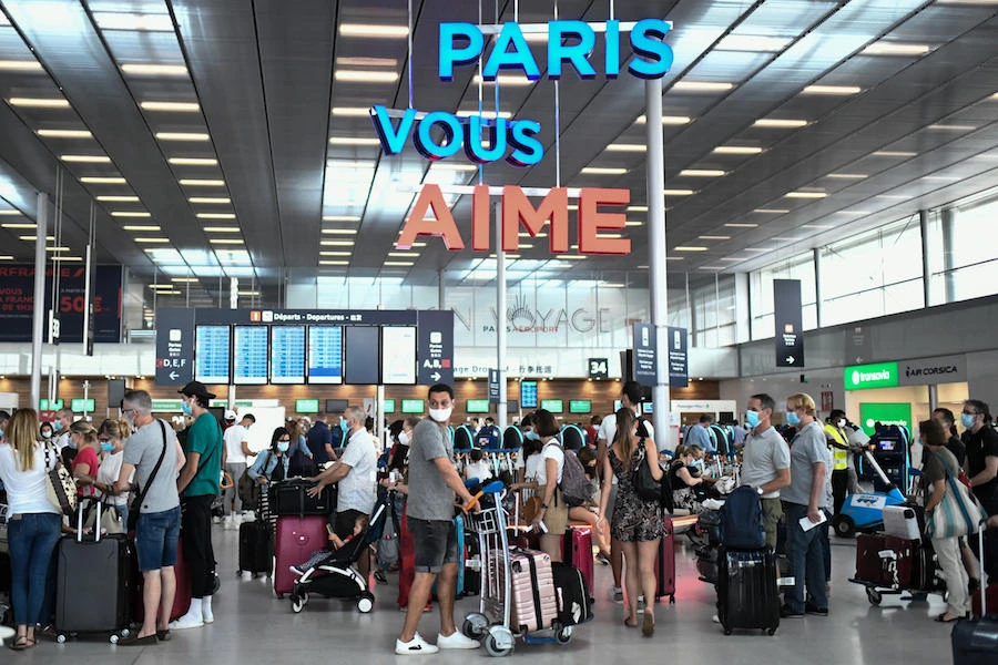 Travelers, wearing protective face masks, line up at the Orly Airport, south of Paris on August 1, 2020 during a major weekend of the French summer holidays. (AFP)