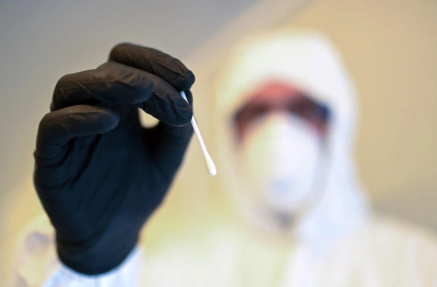 An employee of an aid organisation shows a sample at a newly established Corona testing station in Dortmund, western Germany, on August 1, 2020, amid the new coronavirus COVID-19 pandemic. (AFP)