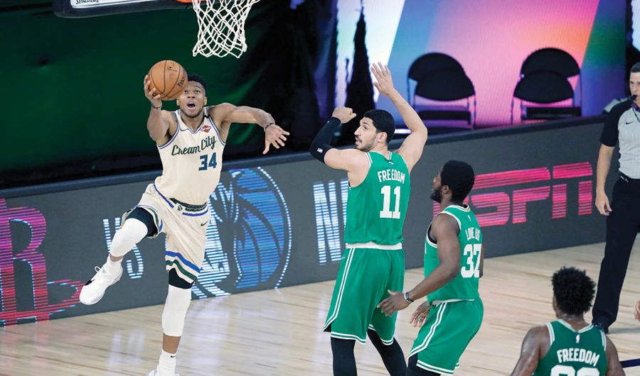 Milwaukee Bucks’ Giannis Antetokounmpo on his way to scoring 36 points past Boston Celtics’ Enes Kanter (11), Semi Ojeleye (37) and Marcus Smart (36) in their NBA game Friday. (Reuters)