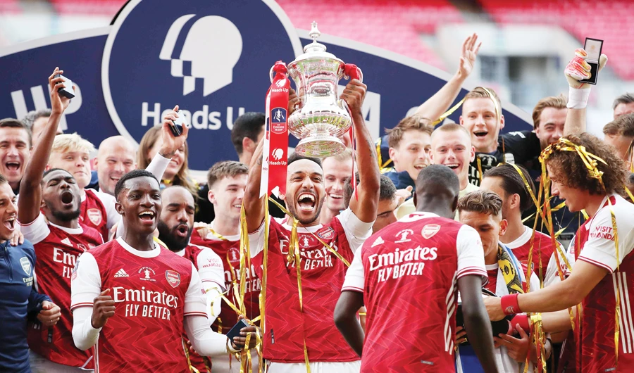 Arsenal’s Gabonese striker Pierre-Emerick Aubameyang with the winner’s trophy as the team celebrate victory after the English FA Cup final against Chelsea. (AFP)