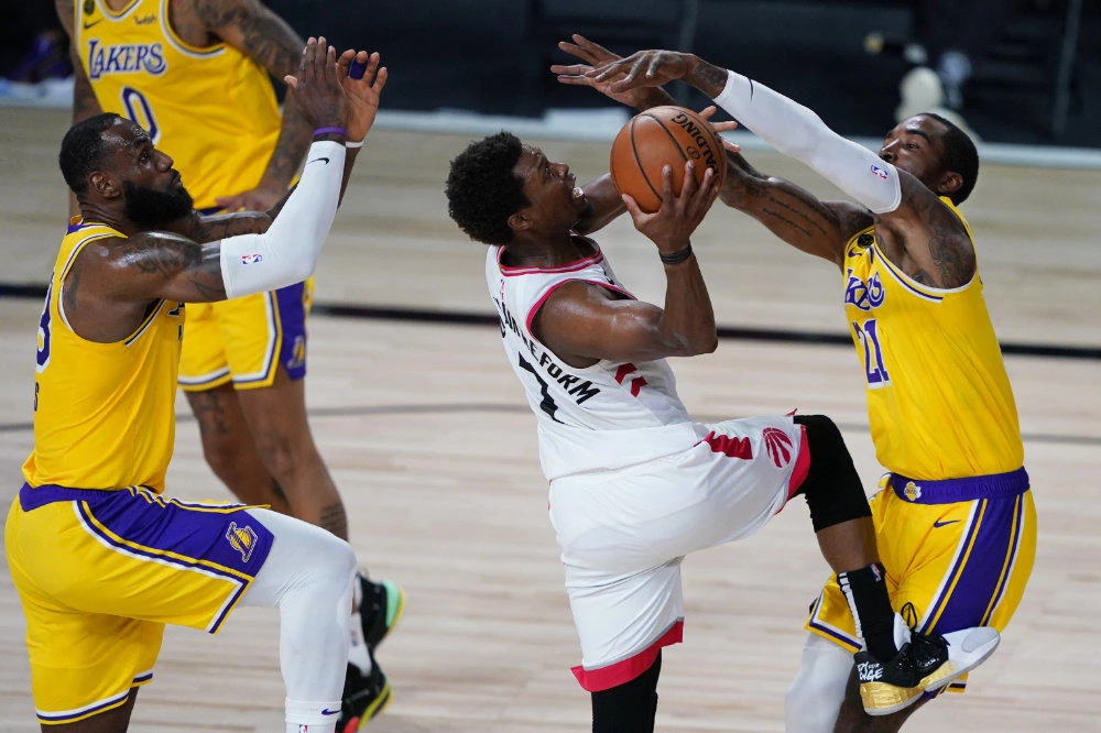 Los Angeles Lakers' LeBron James, left, and JR Smith, right, guard Toronto Raptors' Kyle Lowry during the second half of an NBA basketball game on Aug. 1, 2020, in Lake Buena Vista, Fla. (AP Photo/Ashley Landis, Pool)
