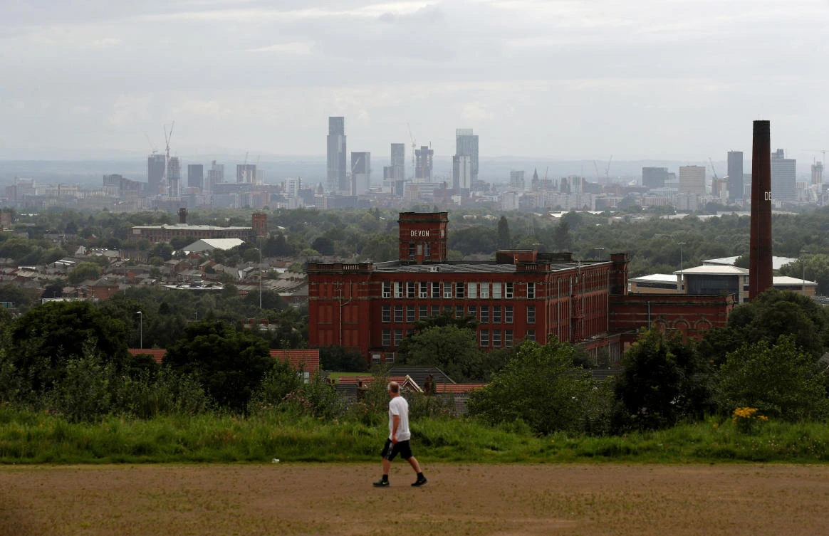 The skyline of Manchester is seen as a man exercises, amid the spread of the coronavirus disease (COVID-19), in Oldham, Britain, August 1, 2020. (Reuters)