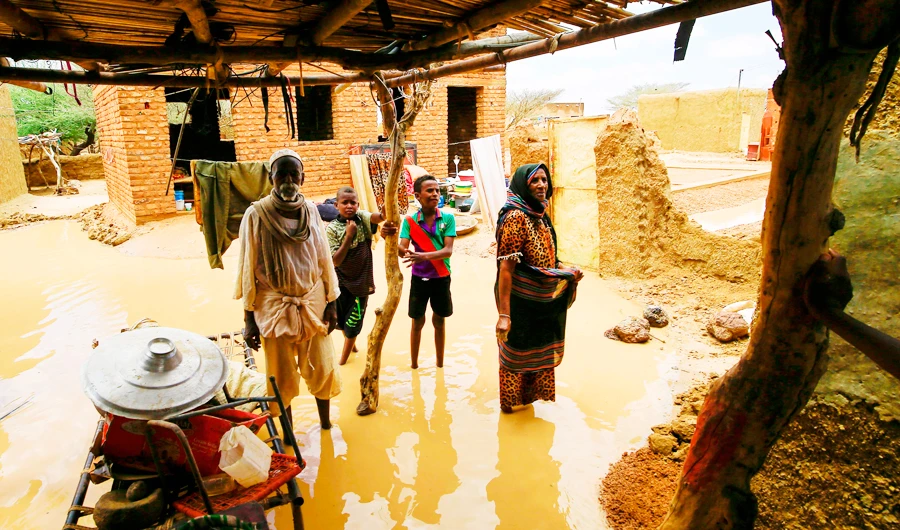 A Sudanese family inspect the damages to their home, after torrential rain led to landslides and flash floods, in the town of Umm Dawan Ban, southeast of Khartoum. (AFP)