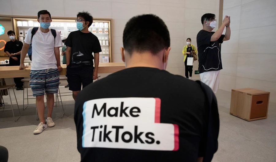 A man wearing a shirt promoting TikTok is seen at an Apple store in Beijing. US President Donald Trump says he wants to take action to ban TikTok. (AFP/File)