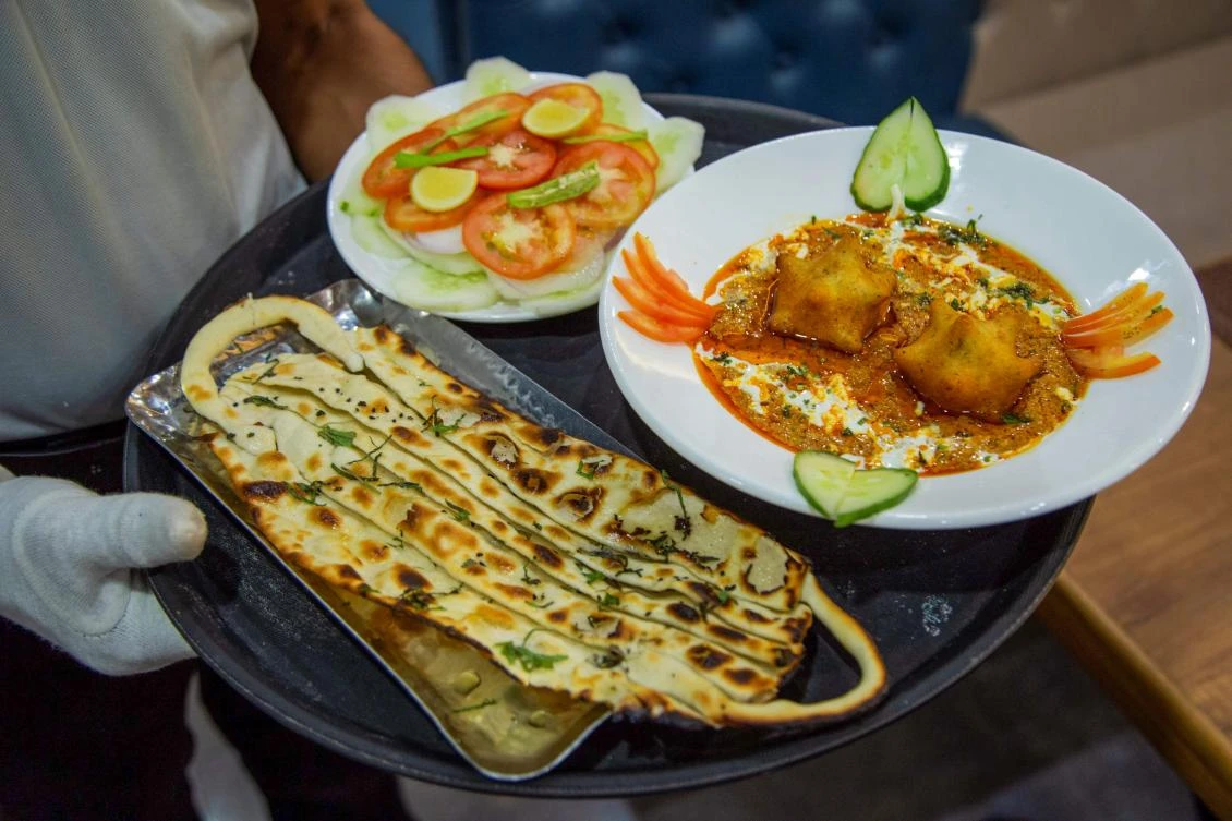 A waiter serves ‘Covid Curry’ and ‘Mask Naan,’ two Covid-19 coronavirus-themed dishes, at a restaurant in Jodhpur on August 3, 2020. (AFP)