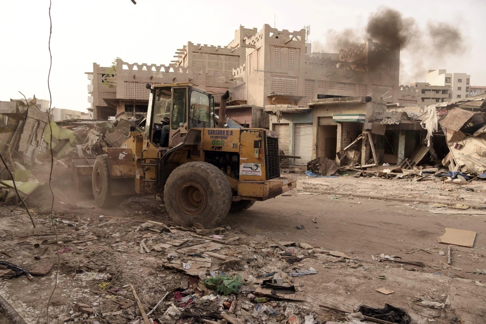 Caterpillars are seen in action at the start of the demolition work of the Sandaga market in Dakar on August 2, 2020. (AFP / Seyllou)