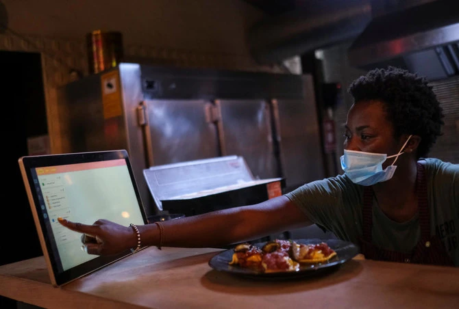 An employee using the "Funky Pay" app informs clients that their order is ready, at Funky Pizza restaurant, where the app replaces waiters, in Palafrugell, near Girona, Costa Brava, Spain July 31, 2020. Picture taken July 31, 2020. (Reuters)