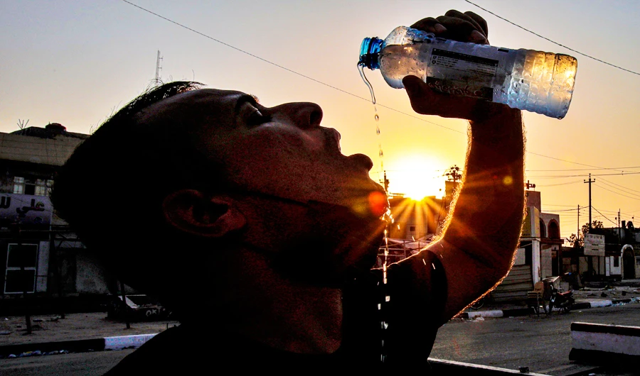 Laith Jabbar, a gas station worker drinks water in Basra, Iraq, Monday, July. 27, 2020. (AP)