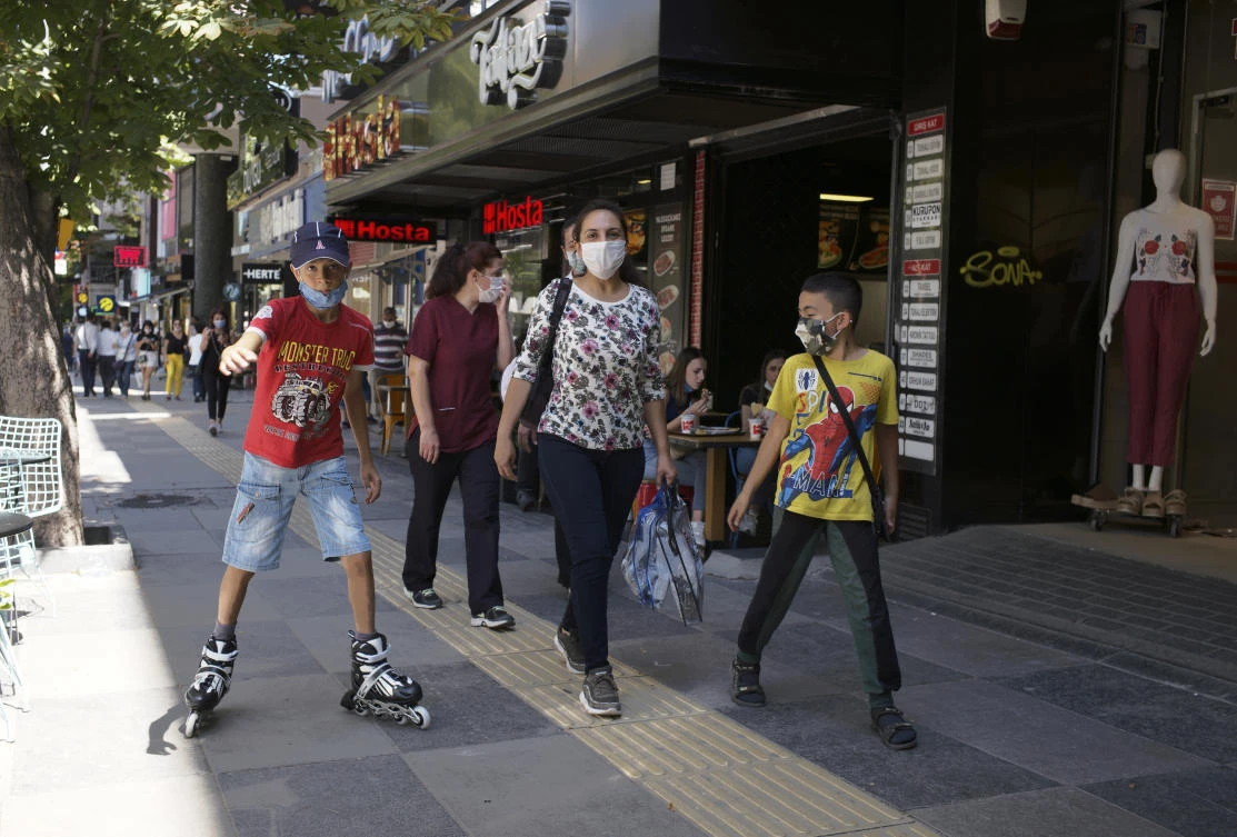 People wearing face masks to protect against the spread of coronavirus, walk in Ankara, Turkey, Wednesday, Aug. 5, 2020. (AP)