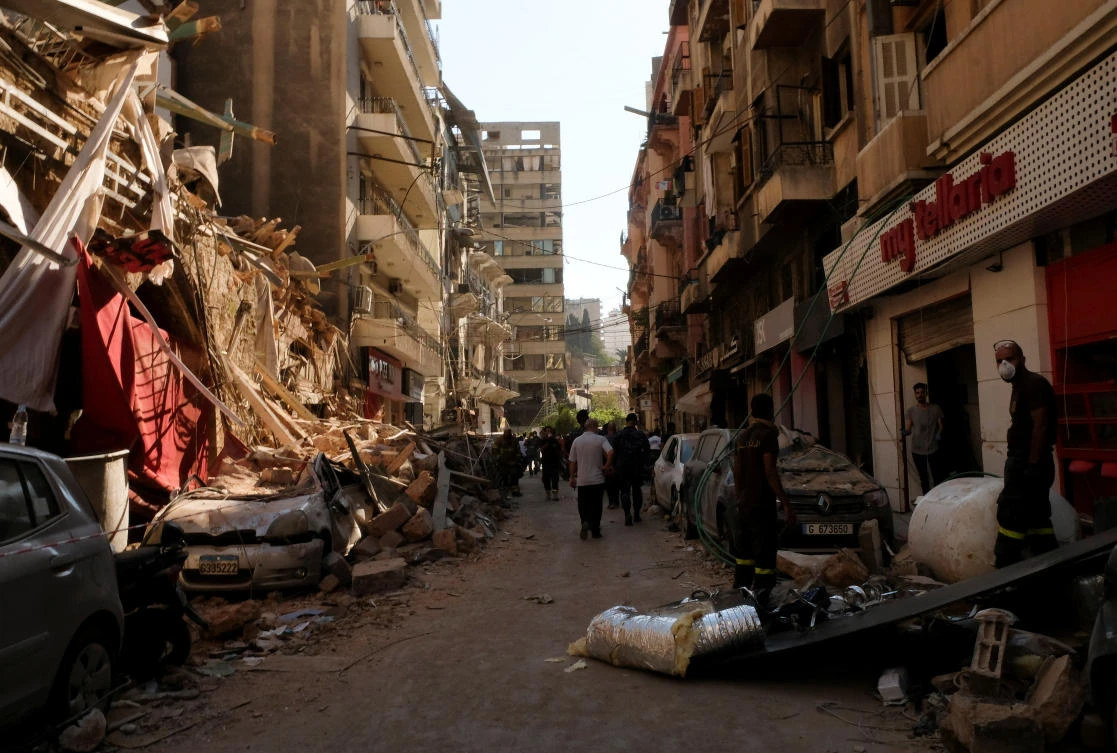 People walk past damaged buildings and vehicles following Tuesday's blast in Beirut's port area, Lebanon August 5, 2020. (Reuters)