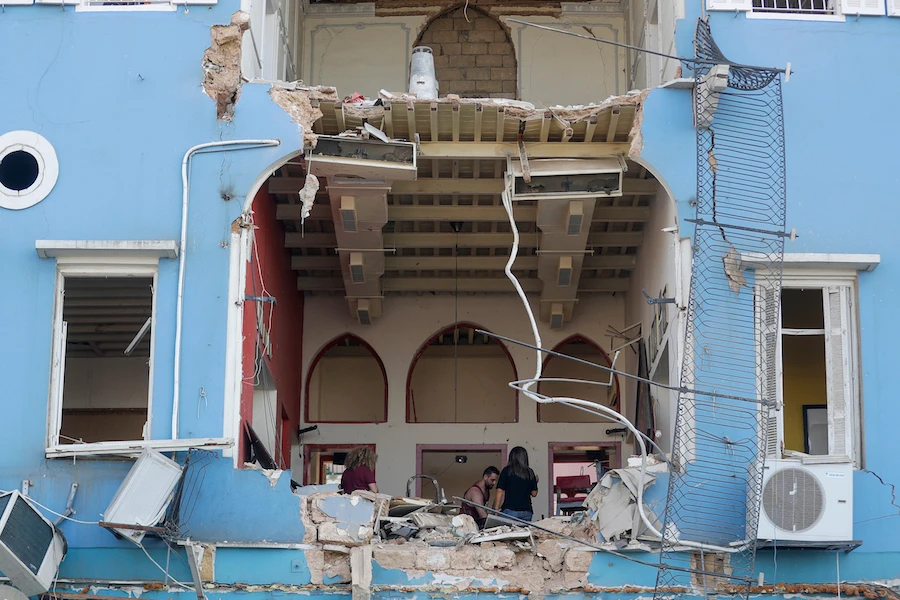 A Lebanese couple inspect the damage to their house in an area overlooking the destroyed Beirut port on August 5, 2020 in the aftermath of a massive explosion in the Lebanese capital. (AFP)