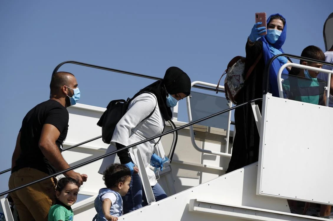 Families board an airplane bound for Iraq at Eleftherios Venizelos International Airport in Athens, Thursday, Aug. 6, 2020. (AP Photo)