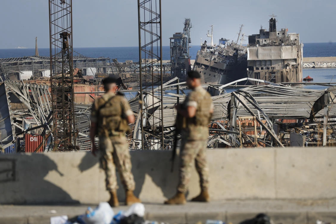 Lebanese army soldiers stand guard in front of destroyed ships at the scene where an explosion hit on Tuesday. (AP)