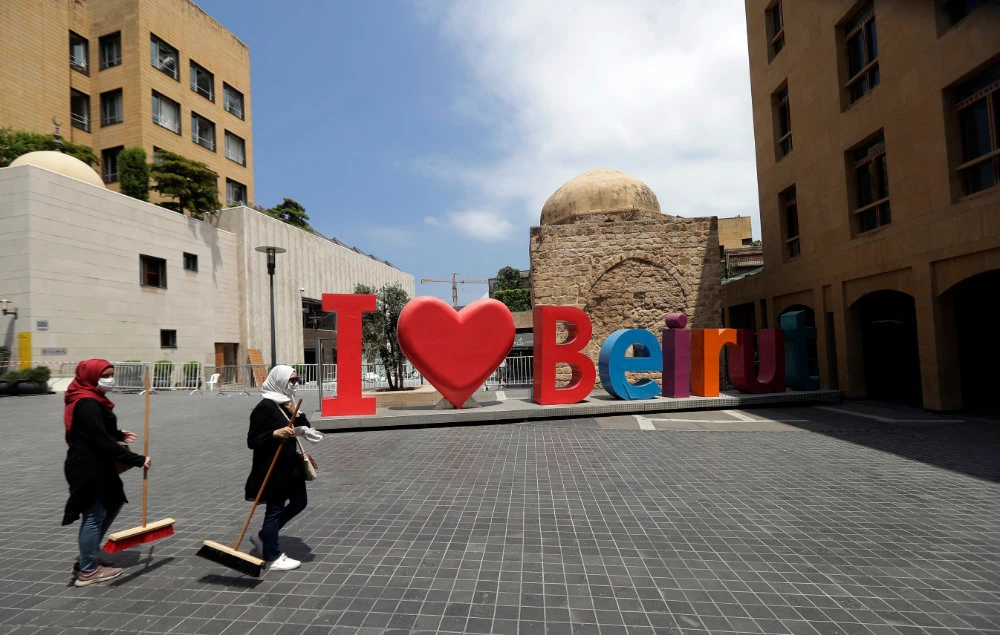 Volunteers clean the rubble and broken glass from the streets in downtown Beirut on August 6, 2020 in the aftermath of the massive explosion. (Photo by JOSEPH EID / AFP)