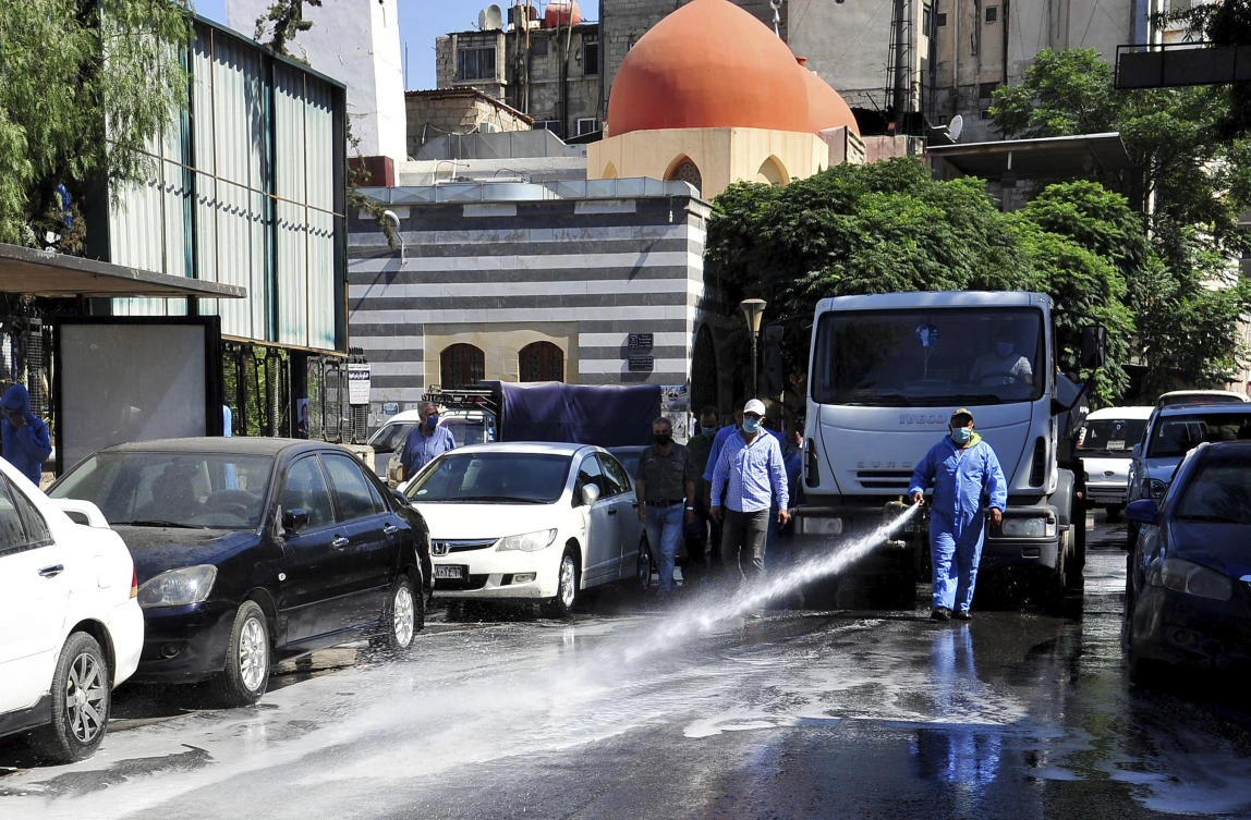 A Syrian worker disinfectants a street to prevent the spread of the coronavirus, in Damascus, Syria, Monday, Aug. 3, 2020. (AP)