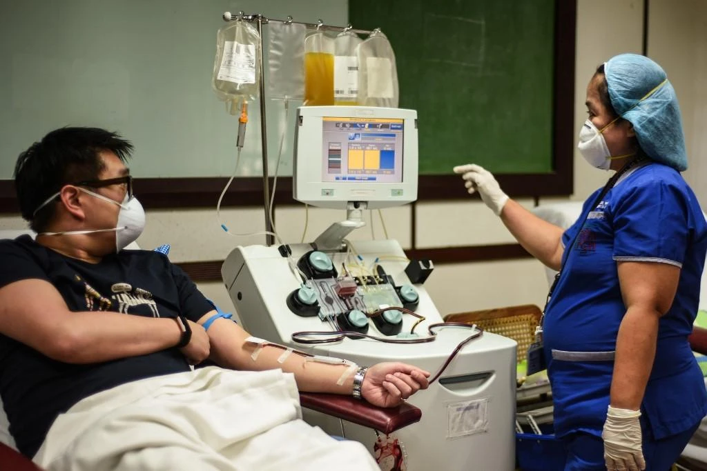 Above, a nurse checks on a patient who has recovered from COVID-19 as he donate plasmas at a hospital in Manila on April 22, 2020. (AFP)
