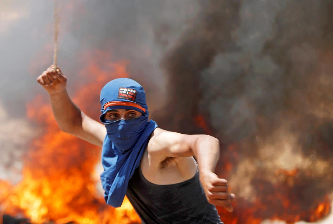 A Palestinian demonstrator uses a sling to hurl stones at Israeli troops during a protest against Jewish settlements and Israel’s plan to annex parts of the occupied West Bank, near Ramallah August 7, 2020. (Reuters/Mohamad Torokman)