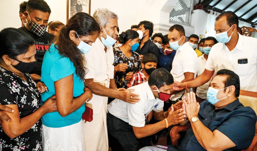 Prime Minister Mahinda Rajapaksa, right, greets supporters at his home in the southern town of Tangalle on Friday, after winning the parliamentary elections. (AFP)