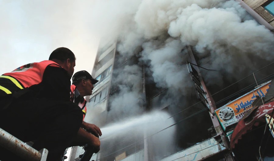 Palestinian firefighters try to extinguish a fire after an Israeli airstrike, on a floor in a building that also houses international media offices in Gaza City. (Reuters/File)