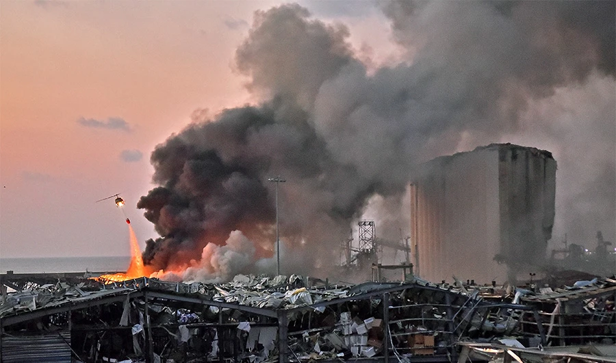 A helicopter puts out a fire at the scene of an explosion at the port of Lebanon's capital Beirut on August 4, 2020. (AFP)