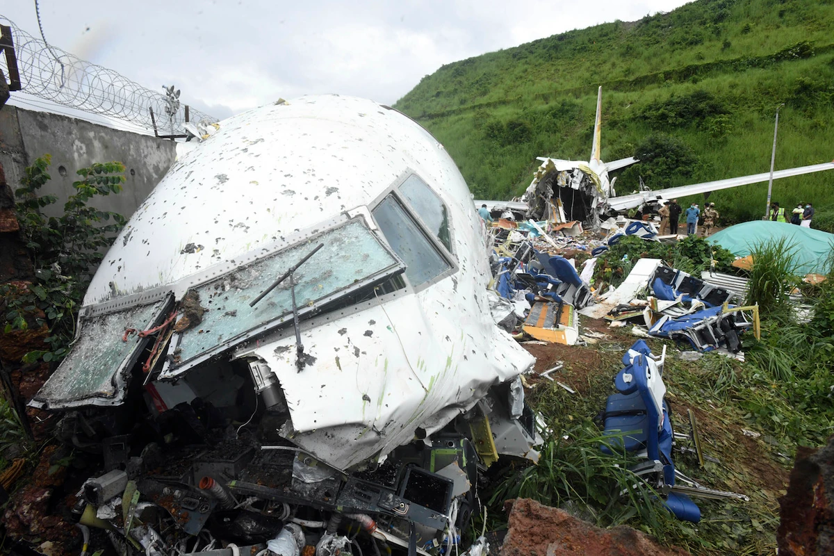 People stand by the debris of the Air India Express flight that skidded off a runway while landing in Kozhikode, Kerala state, India, Saturday, Aug. 8, 2020. (AP)