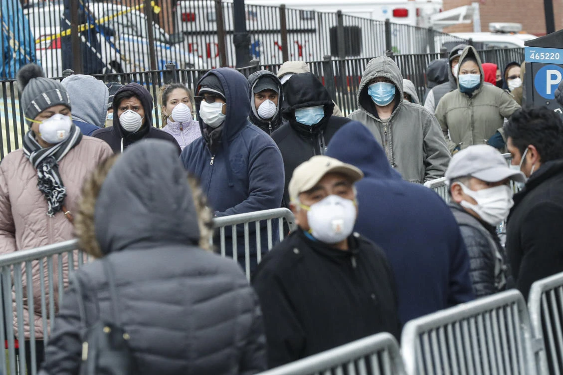 In this March 25, 2020, file photo, patients wear personal protective equipment while maintaining social distancing as they wait in line for a COVID-19 test at Elmhurst Hospital Center, in New York. (AP)