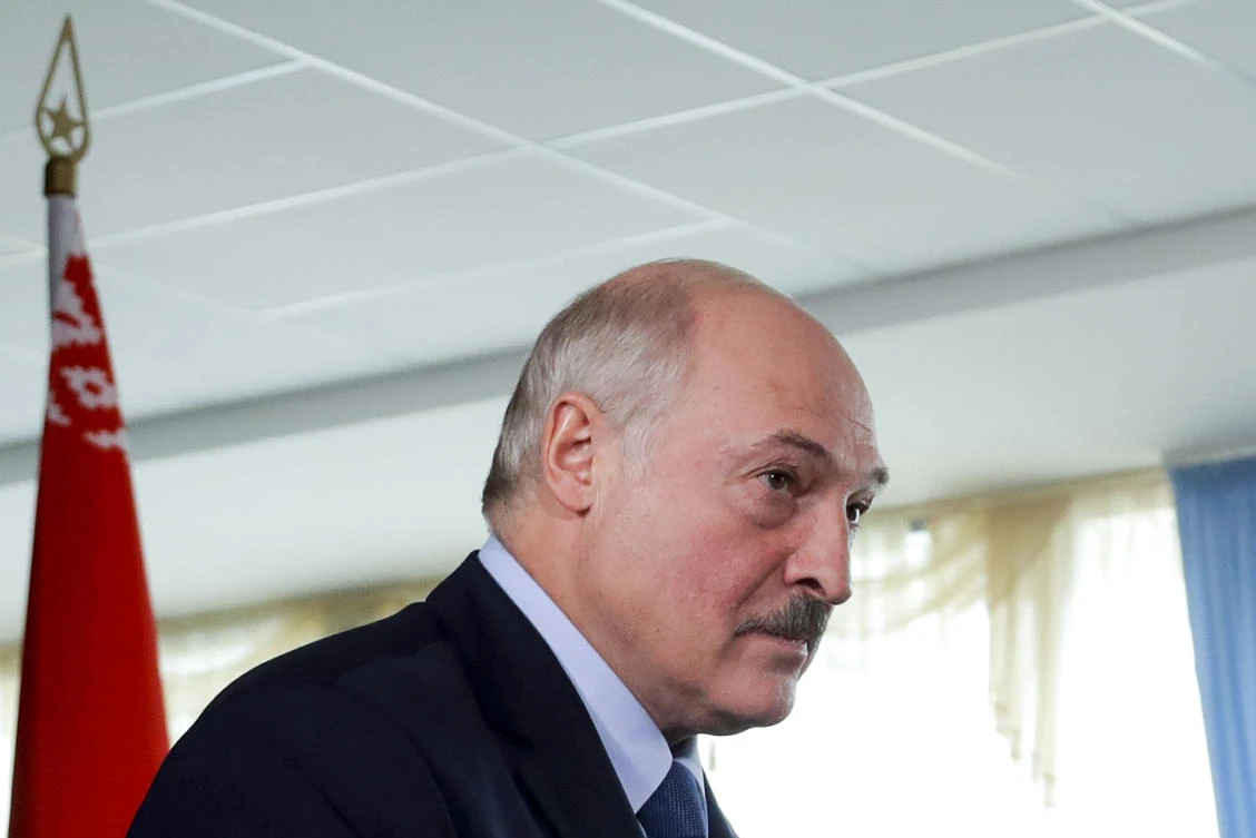 Belarusian President Alexander Lukashenko walks after voting at a polling station with a Belarusian national flag on the left, during the presidential election in Minsk, Belarus, Sunday, Aug. 9, 2020. (AP)