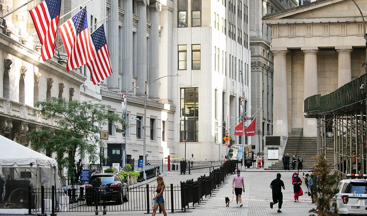 People walk by the New York Stock Exchange. Wall Street is drifting in early trading on Monday, Aug. 10, after President Donald Trump announced several stopgap moves to aid the economy. (AP)