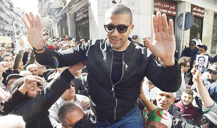 Algerian journalist Khaled Drareni is carried by protesters in this file photo. (AFP)