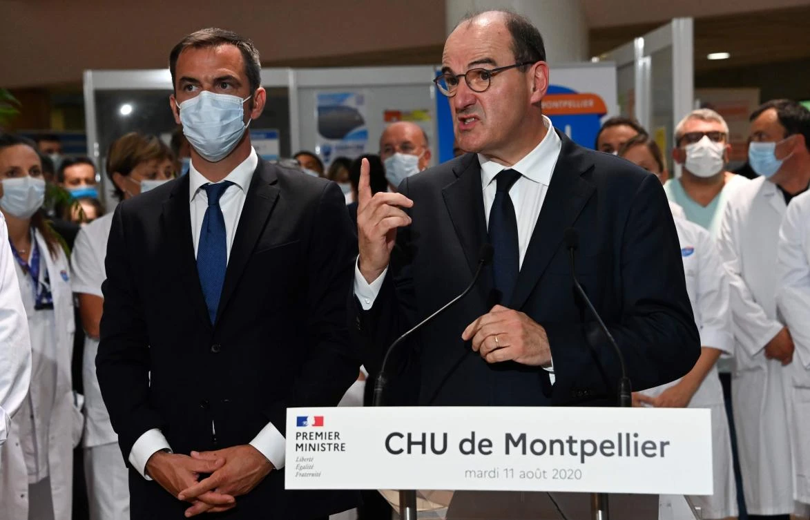 French Prime Minister Jean Castex (R), flanked by French Health Minister Olivier Veran (L), gestures as he delivers a speech during a visit at the CHU hospital in Montpellier. (AFP)