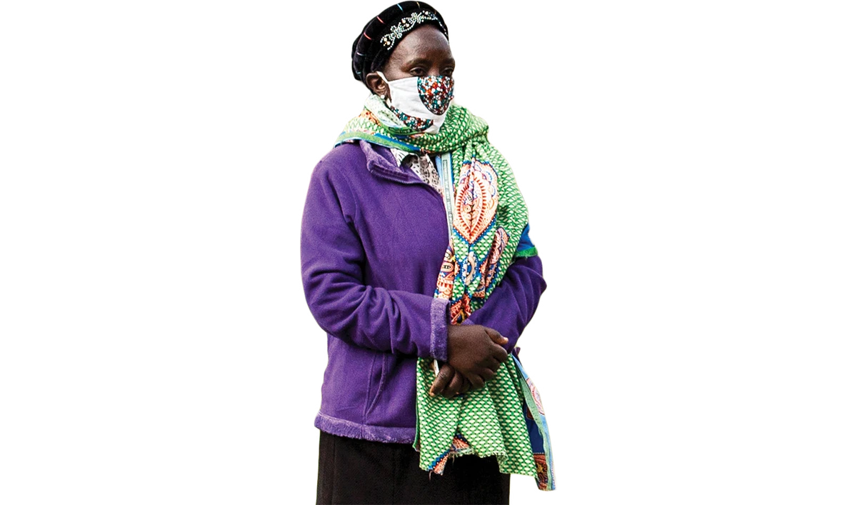 A woman waits, while adhering to social distancing, for a food distribution in Nairobi. (AFP)