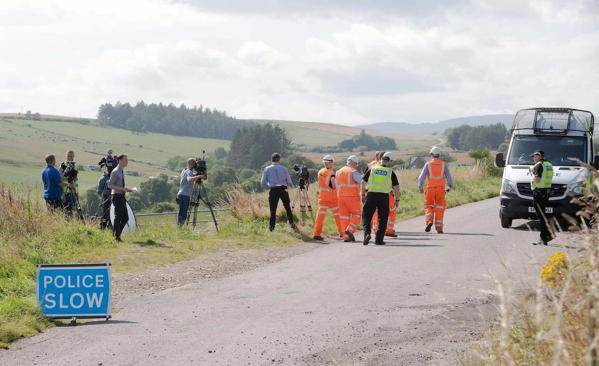 Network Rail engineers walk past members of the media near the scene of a train crash by Stonehaven in northeast Scotland on August 12, 2020. (AFP)