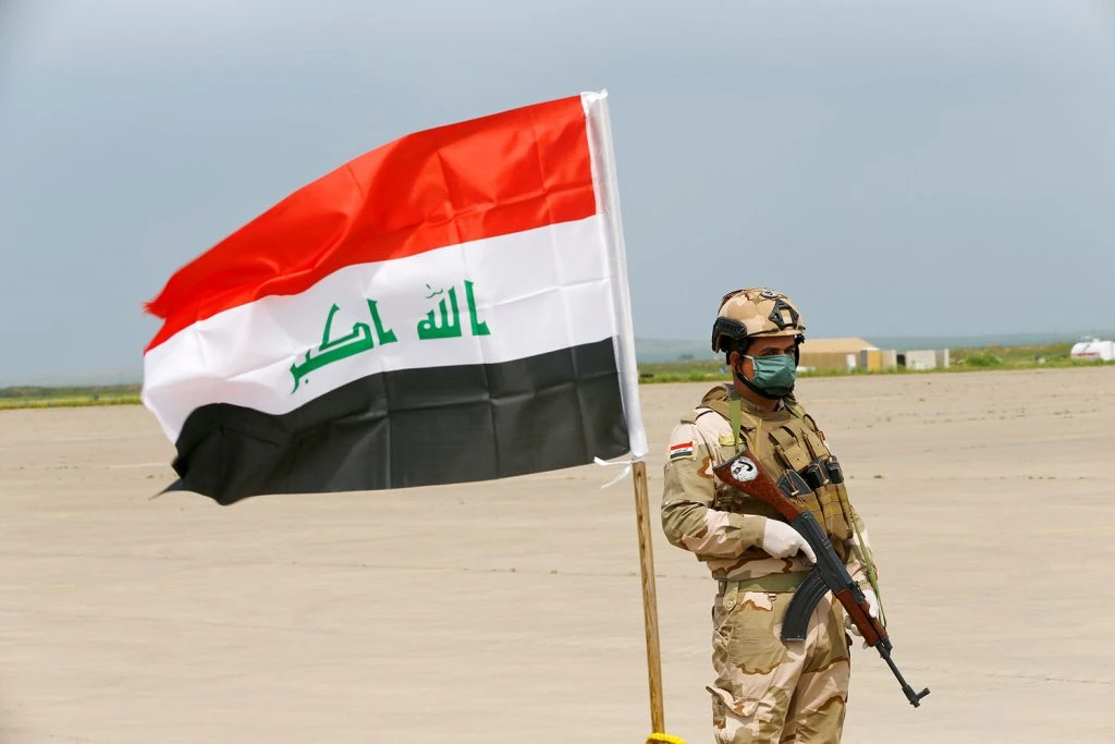 An Iraqi soldier wears a protective face mask and gloves, following the outbreak of coronavirus disease (COVID-19), as he stands guard during the hand over of Qayyarah Airfield West from US-led coalition forces to Iraqi Security Forces, in the south of Mosul, Iraq March 26, 2020. (Reuters)