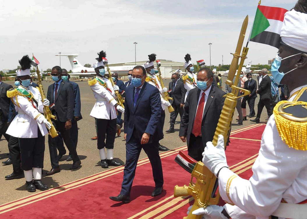 PM Mostafa Madbouli (C-L) is received by Sudan's PM Abdalla Hamdok (C-R) at the capital's Khartoum International Airport. (AFP)