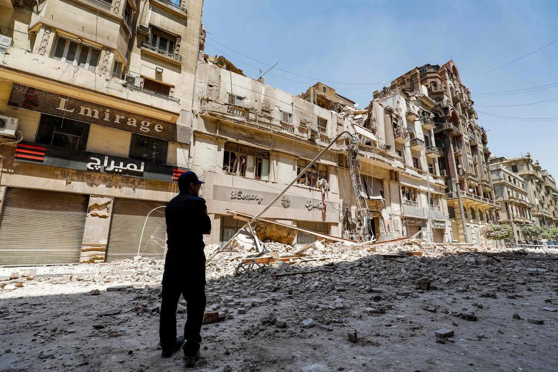 A policeman stands by the rubble at the scene of a building collapse along Kasr Al-Nile street in the Egyptian capital Cairo's downtown district, on August 15, 2020. (AFP)