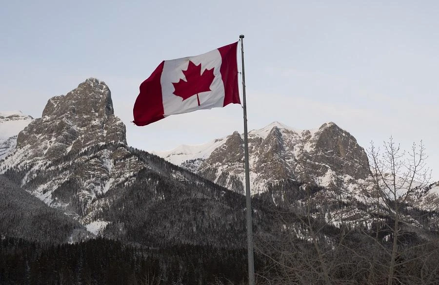 The Canadian flag flies over the Canadian Rockies at the Canmore Nordic Center on February 7, 2019 in Canmore, Canada. (File/AFP)