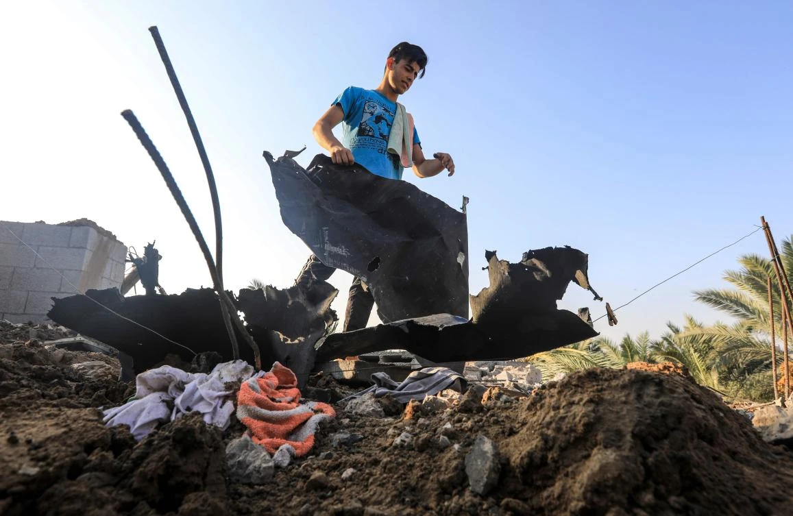 A youth inspects rubble and debris and other damages on a rooftop following an Israeli air strike, east of Al-Bureij camp for Palestinian refugees in the central Gaza Strip on August 15, 2020. (AFP)