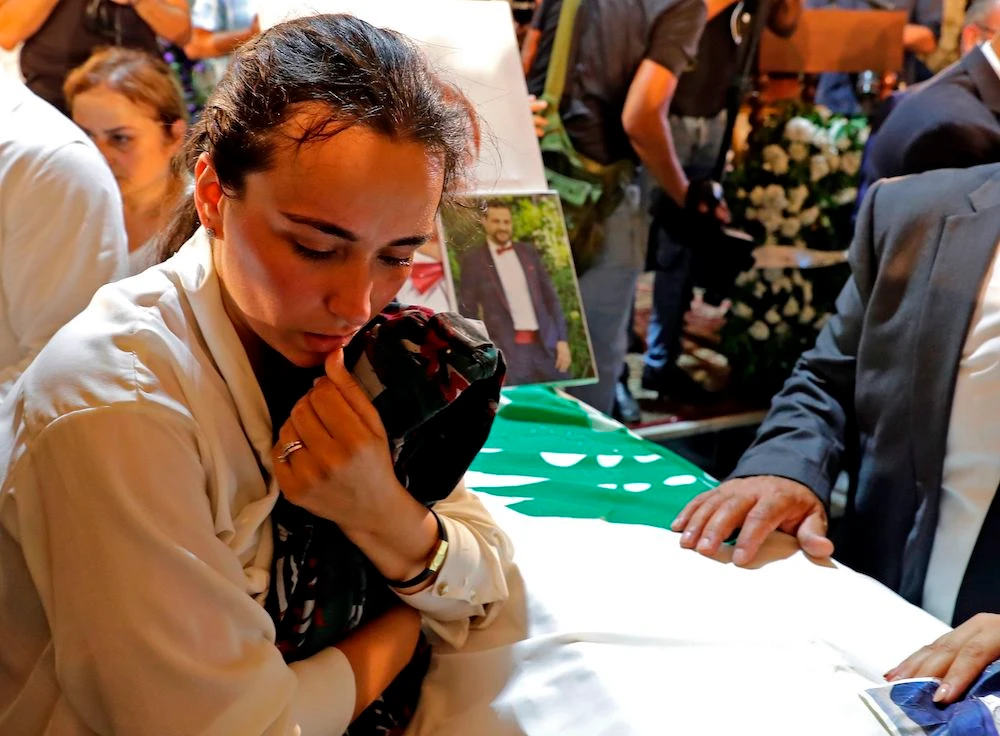 Karlen during the funeral of her husband Charbel Karam, brother Najib Hitti, and cousin Charbel Hitti in Qartaba, north of Beirut. The three firefighters were killed in the Aug. 4 explosion. (AFP)