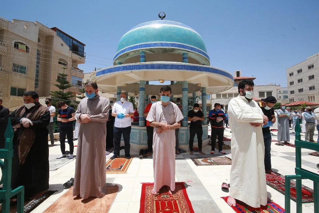 Jordanians keep a safe distance as they gather to pray in the court of Mohammad Al-Tilawy mosque in the capital Amman. (File/AFP)