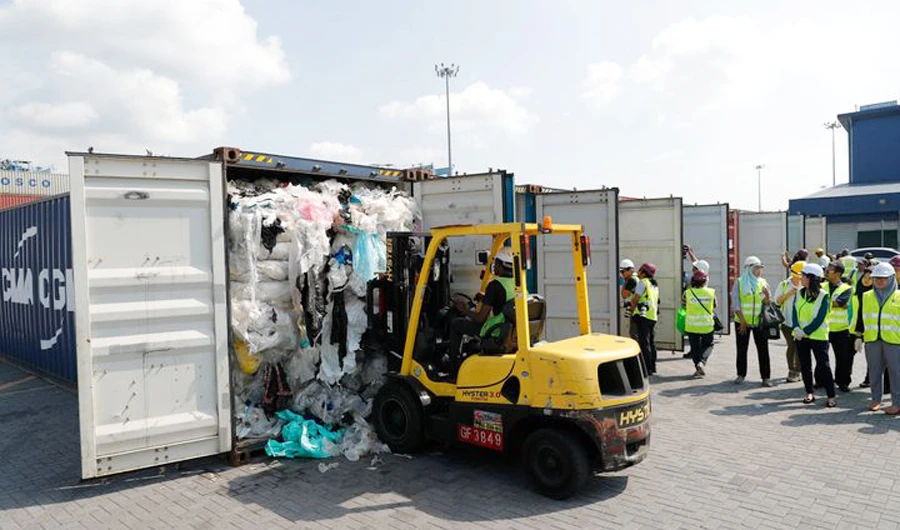 Workers examine a container of plastic waste in Klang, Malaysia. (AP/File)